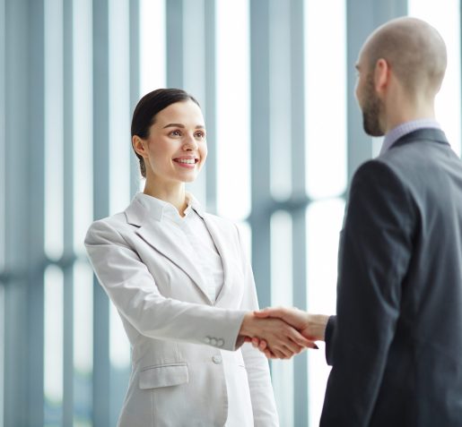 Successful businesswoman greeting her business partner by handshake in airport